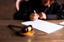 Gavel next to judge doing paperwork